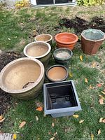 Group of eight assorted planters on grass