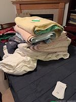 Stack of assorted quilts and duvet on table
