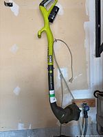 Full view of Ryobi 18V cordless string trimmer with battery attached