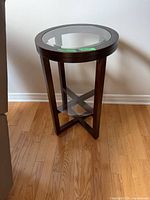 Full view of round side table showing glass top and wood frame