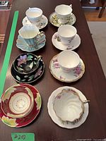eight assorted teacup and saucer sets on table