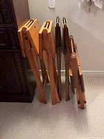 Five folded wooden TV trays leaning together