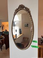 Frontal view of oval metal framed mirror on wall