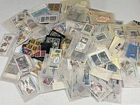 Pile of many glassine envelopes each containing postage stamps