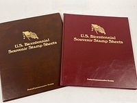 Front covers of both Bicentennial stamp sheet folders