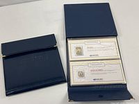 Both United We Stand albums, one open showing stamp pages