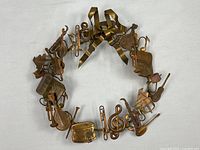 Full view of brass wreath showing all instrument figures and bow