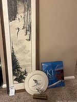 Lot group showing framed ski print, book, plate, sculpture