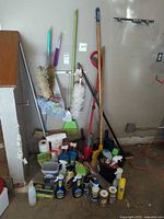 Overall lot showing long-handled tools and cleaning bottles