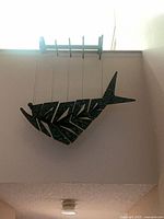 Front view of hanging fish sculpture suspended from bracket