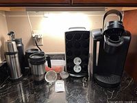 Full set on countertop showing coffee maker, carousel, mugs, filters, container