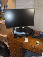 Overall view showing Acer monitor on stand atop Panasonic VCR with cables