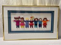Full view of framed artwork showing seven child figures, gold frame, double mat