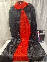 Cape laid flat showing black outside and red lining