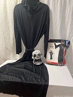 Robe draped with skull mask and retail bag