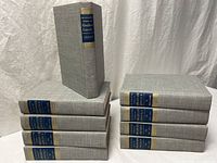 Full set of ten grey cloth volumes, nine stacked horizontally and index standing upright