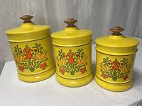 three yellow Kromex canisters with folk art design and lids
