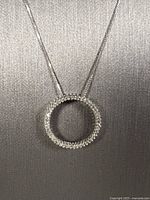 Close-up of circle pendant with pavé diamonds