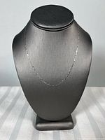 Full view of white gold chain on display bust