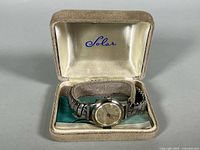 Watch in open Solar box showing dial, bracelet and interior logo