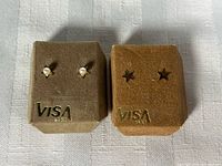 Both pairs of stud earrings on display pads