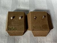 Both earring pairs on display pads