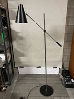 Full view of floor lamp showing shade, arm, stem and base