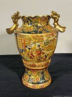 Front view of Royal Satsuma pedestal vase showing overall form and twin gilt handles