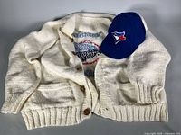 Cap and sweater laid out together showing overall items