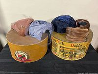 Overall view of two hat boxes with four hats on top