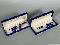 Two Waterman cases opened showing burgundy pen and dark pencil