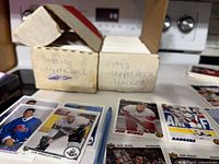 Two white cardboard long boxes labeled 1990-91 Upper Deck and 1992 Upper Deck Hockey with loose cards displayed in foreground