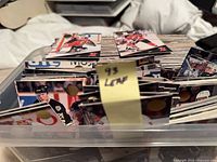 Top view of plastic bin filled with stacked hockey cards, visible 93-94 Leaf band