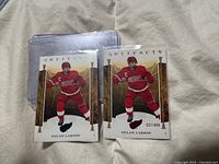 Both Dylan Larkin Artifacts cards in sleeves, Ruby on right showing serial number 237/499, Turquoise on left