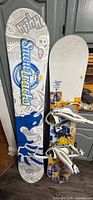 Both snowboards standing side by side for full view