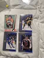 Group shot of four hockey cards in sleeves: Johnny Bucyk 1969-70, Brett Hull GG-3, Paul Coffey GG-6, Luc Robitaille GG-8