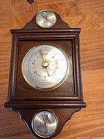 Full view of wood cased weather station showing three dials