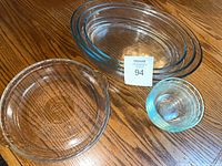 Overview of all glass items: three oval dishes, one pie plate, stack of four Pyrex dishes