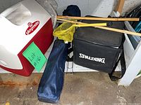 Igloo cooler, Spalding case, chair bag, nets and poles on shelf