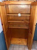 Cabinet doors open showing interior shelves and double doors