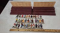 All 35 figurines arranged in front of two tiered display stands with tan name cards