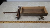 Full side view of wooden toy wagon beside ruler showing 28-inch length