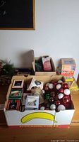 Box of assorted ball ornaments, boxed photo ornaments and surrounding items