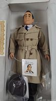 Doll in original box with trench coat, hat accessory bag visible