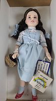 Full view of Dorothy doll in box with outfit and basket
