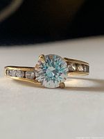 Ring front view showing central clear stone and shoulder accents