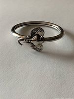 Side view of silver bangle showing elephant head detail