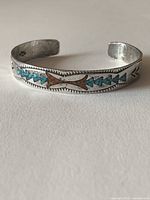 Top view of silver cuff bracelet showing full inlay pattern.