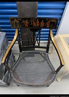 Top view of armchair showing cane seat, lacquer finish, gold painted crest rail