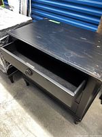 Nightstand front view with one drawer open showing interior and knob detail